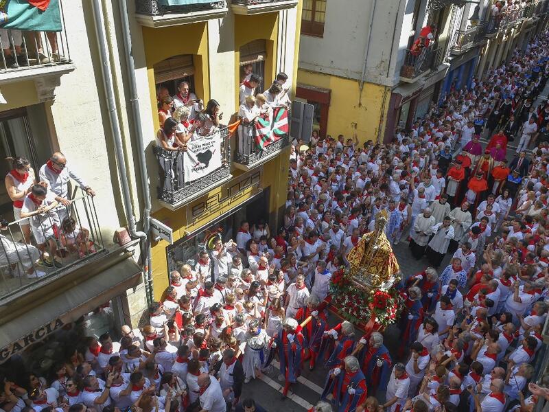 People look at the procession of Pamplona´s patron Saint Fermin on the first day of the San Fermin bullrun festival in Pamplona, northern Spain on July 7, 2019. ANDER GILLENEA / AFP