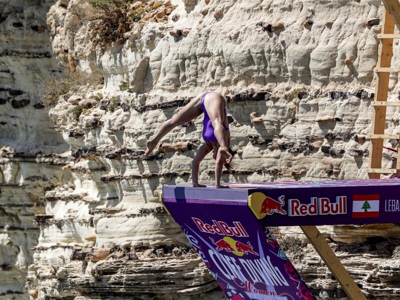 A cliff diver prepares to jump from a platform on the landmark Raouche sea rock off the coast of the Lebanese capital Beirut on July 14, 2019, during the women's 2019 Red Bull Cliff Diving World Series.  ANWAR AMRO / AA / AFP
