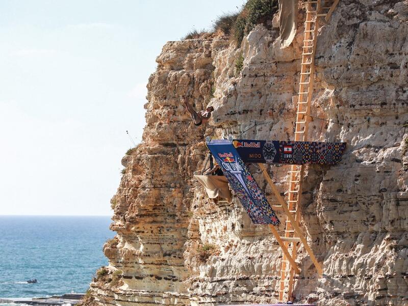 A cliff diver jumps from a platform on the landmark Raouche sea rock off the coast of the Lebanese capital Beirut on July 14, 2019, during the men's 2019 Red Bull Cliff Diving World Series.  ANWAR AMRO / AA / AFP
