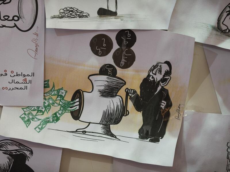 This picture taken on June 16, 2019, shows various illustrations by Syrian Cartoonist Amani al-Ali at her home studio in the city of Idlib in the eponymous northwestern province.  Omar HAJ KADOUR / AFP