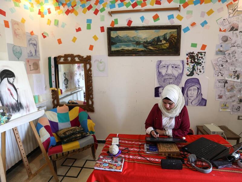 Syrian Cartoonist Amani al-Ali draws an illustration on a digital tablet device in her home studio in the city of Idlib in the eponymous northwestern province Omar HAJ KADOUR / AFP