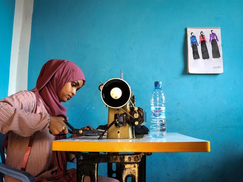 Hawa Adan Hassan, 23 year-old, university student, uses a sewing machine at her home in Mogadishu, Somalia. Abdi HAJJI HUSSEIN / AFP