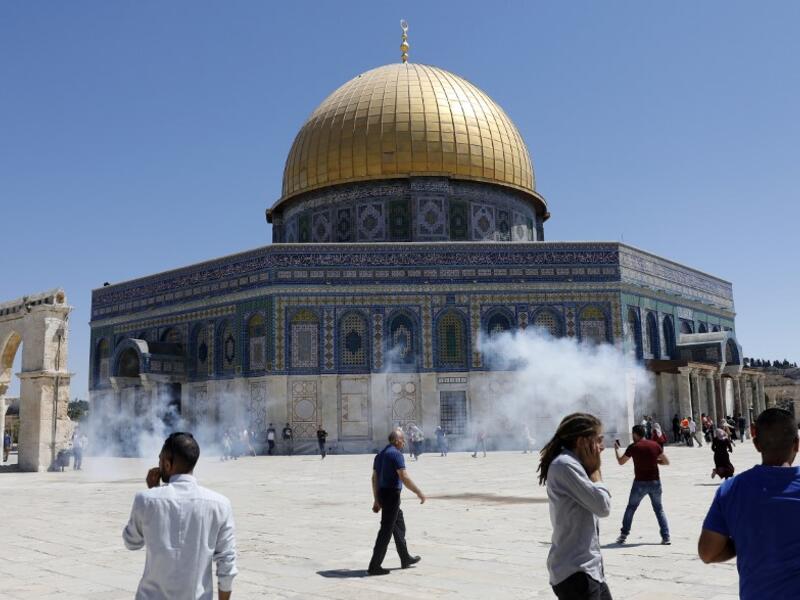 Palestinians run for cover from sound grenades fired by Israeli security forces outside the Dome of the Rock mosque in Jerusalem's Al-Aqsa Mosque compound on August 11, 2019. (AFP/ File Photo)
