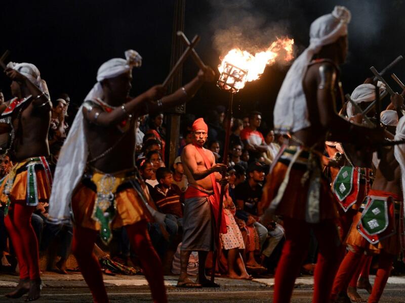 In this photograph taken on August 14, 2019 dancers perform during the "Esala Perahera" festival near the Buddhist temple of the Tooth in the ancient hill capital of Kandy, some 116 kilometres from Colombo. Lakruwan WANNIARACHCHI / AFP