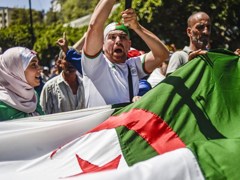 Algerian demonstrators chant slogans and march with national flags as they gather in the streets of the capital Algiers. (AFP/ File Photo)