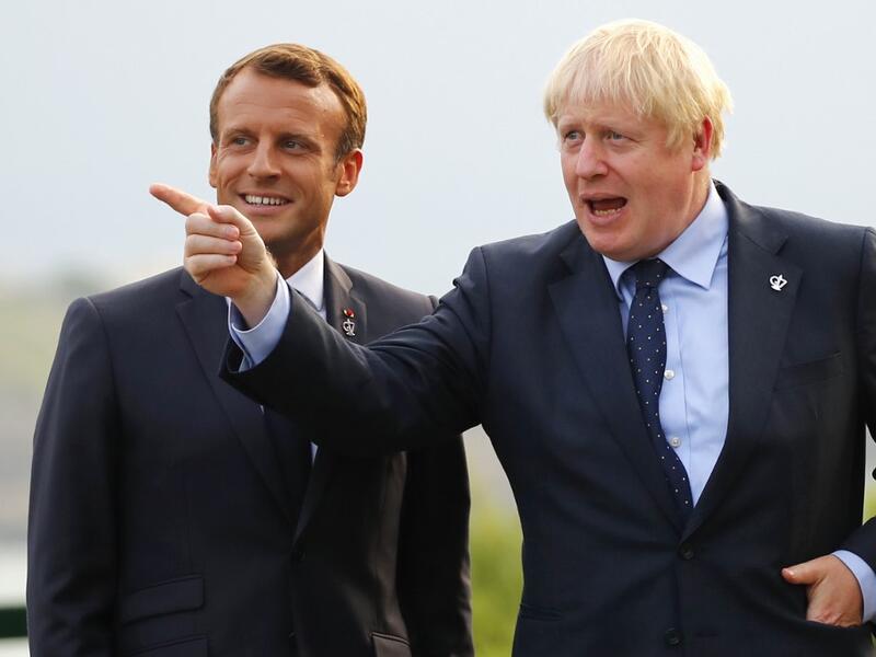 British Prime Minister Boris Johnson (R) gestures past French President Emmanuel Macron at the Biarritz lighthouse, southwestern France, ahead of a working dinner on August 24, 2019. Francois Mori / POOL / AFP