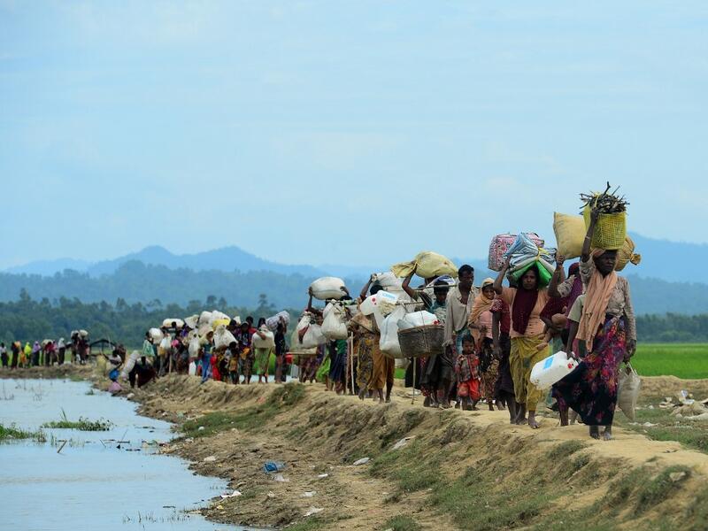 October 19, 2017 Rohingya refugees who were stranded walk near the no man's land area between Bangladesh and Myanmar in the Palongkhali area next to Ukhia. Munir UZ ZAMAN / AFP