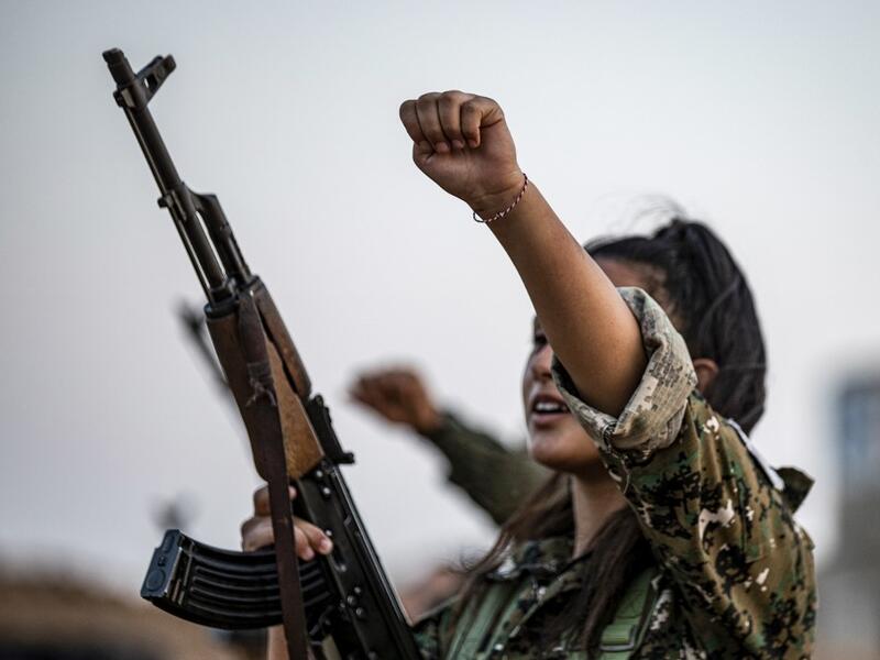 A member of the Bethnahrin Women Protection Forces (HSNB), an all-female Syriac-Assyrian paramilitary group under the umbrella of the Syrian Democratic Forces (SDF), chants slogans as during a commemoration of the fourth anniversary of their creation, in the countryside of the town of Tall Tamr in the northwestern Syrian province of Hasakah, on August 30, 2019.  Delil SOULEIMAN / AFP