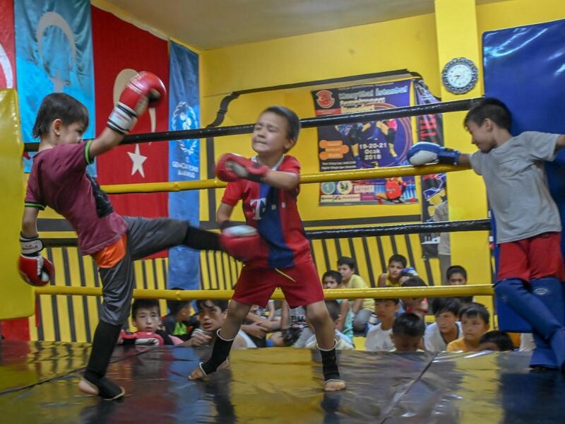 In this photograph taken on August 29, 2019, children from Muslim Uighur minority take part in a training boxing match as a trainer and children watch in Istanbul. BULENT KILIC / AFP
