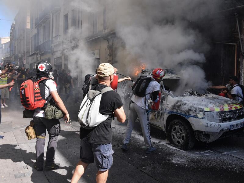 Street medics use a fire extinguishers on a burning French Municipal Police car on the sidelines of an anti-government demonstration called by the "Yellow Vests" (Gilets Jaunes) movement in Montpellier, southern France on September 7, 2019. Pascal GUYOT / AFP