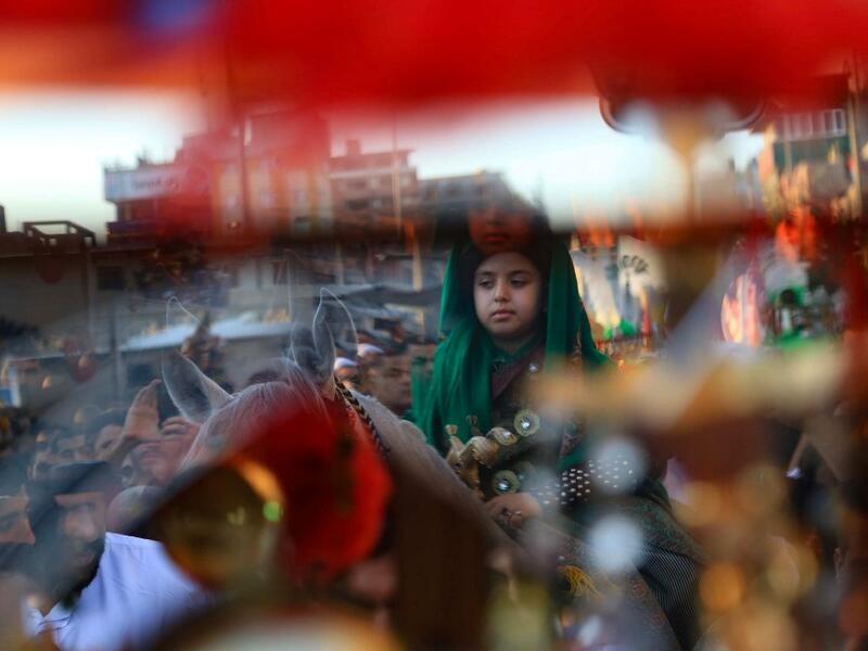 A young boy parades on horeseback as Iraqi Shiite Muslims gather during a ceremony marking the 7th day of Muharram as part of Ashura in the central Iraqi city of Karbala  (AFP)
