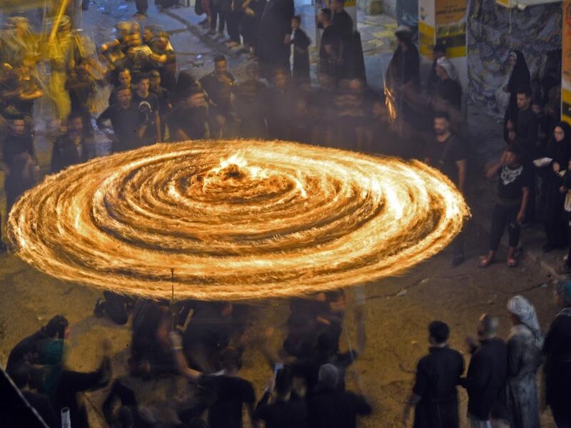 Iraqi Shiite Muslims perform mourning rituals during a ceremony marking the 7th day of Muharram as part of Ashura in the Iraqi holy city of Najaf. Ashura, one of the holiest days in Shiite Islam, commemorates the seventh century killing of Prophet Mohammed's grandson Imam Hussein. Haidar HAMDANI / AFP
