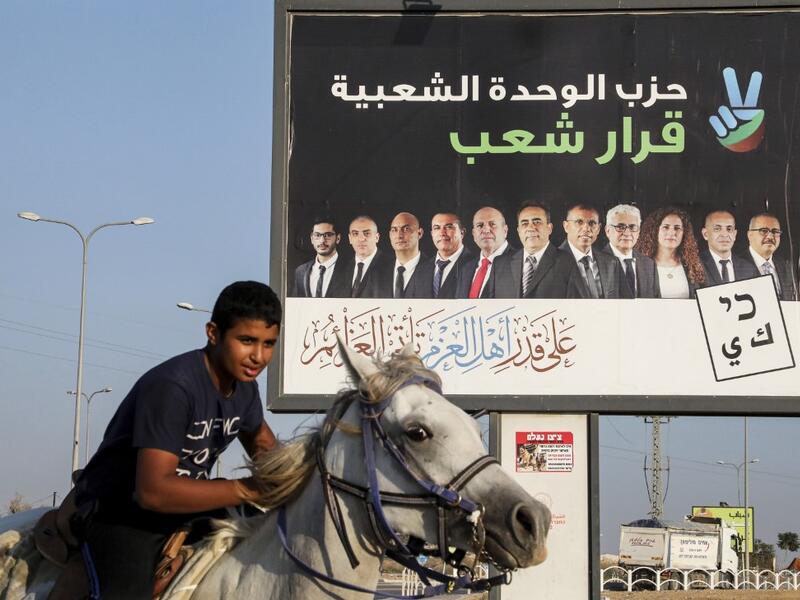 Electoral billboard for the Popular Unity party with its candidates and a slogan in Arabic reading "the decision of the people", in the Bedouin town of Rahat near the southern Israeli city of Beersheba. HAZEM BADER / AFP
