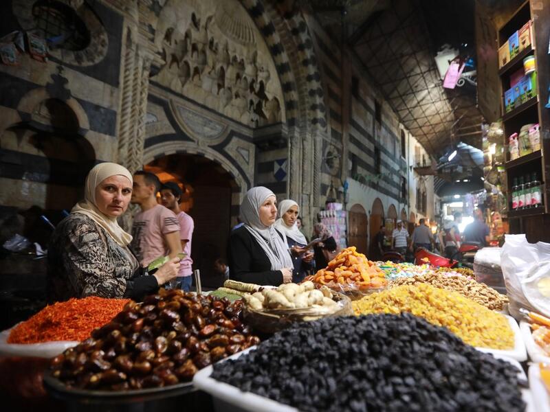 Women run errands at the Bzourieh market in the center of Damascus. LOUAI BESHARA / AFP