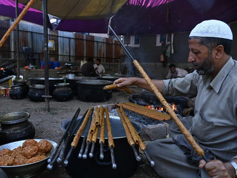 In this photo taken on September 15, 2019, chefs prepare long kebabs made from minced meat ahead of a traditional feast held for a marriage ceremony in Kashmir's Baramulla district, north of Srinagar. TAUSEEF MUSTAFA / AFP
