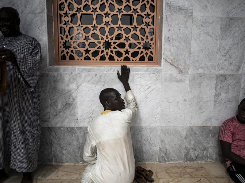 Worshippers are seen waiting outside the Great Mosque of the Mourides on September 27, 2019 in Dakar, ahead of its inauguration. Senegal's influential Mouride Brotherhood will inaugurate a 30,000-capacity mosque in the capital Dakar, said to be the largest in West Africa. JOHN WESSELS / AFP