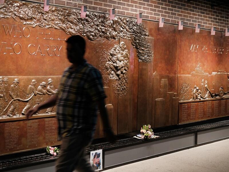 People walk by a memorial to fallen firefighters near the World Trade Center Memorial in lower Manhattan in New York City. New York City is preparing to commemorate the 18th anniversary of the attacks on the World Trade Center in which 2,996 people were killed and over 6000 were injured. Spencer Platt/Getty Images/AFP SPENCER PLATT / GETTY IMAGES NORTH AMERICA / AFP
