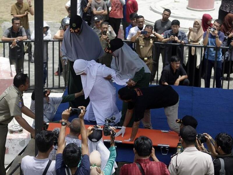 Indonesian woman collapses in pain (Twitter)