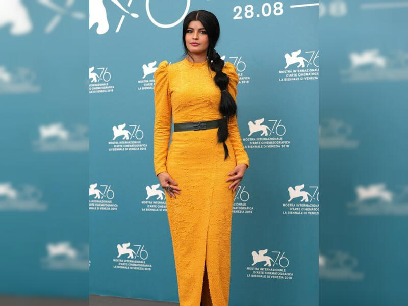 For her second appearance, she wore a mustard yellow dress designed by Eman Alajlan
