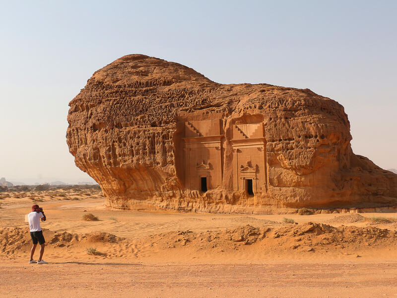 A tourist photographs Area C tombs at Madain Saleh Heritage Site. (Shutterstock/ File Photo)
