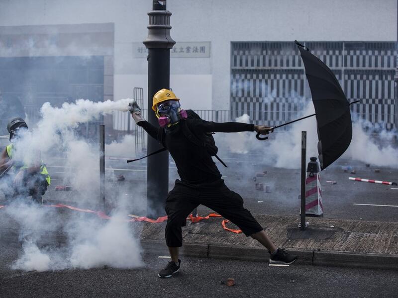 A protester throws a tear gas canister fired by police in the Sha Tin district of Hong Kong on October 1, 2019, as the city observes the National Day holiday to mark the 70th anniversary of communist China's founding. ISAAC LAWRENCE / AFP