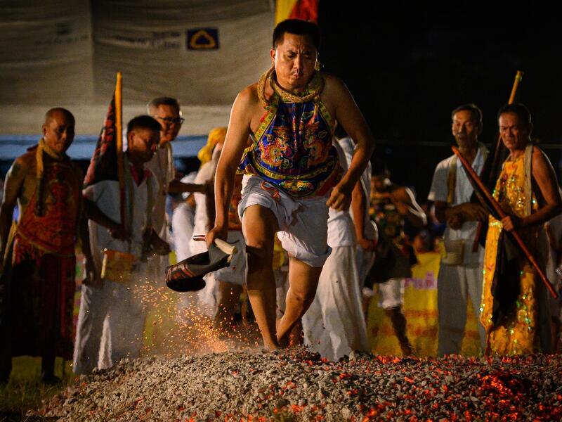 A devotee of a Chinese shrine walks on ambers during the annual Vegetarian Festival in Phuket on October 4, 2019.Mladen ANTONOV / AFP