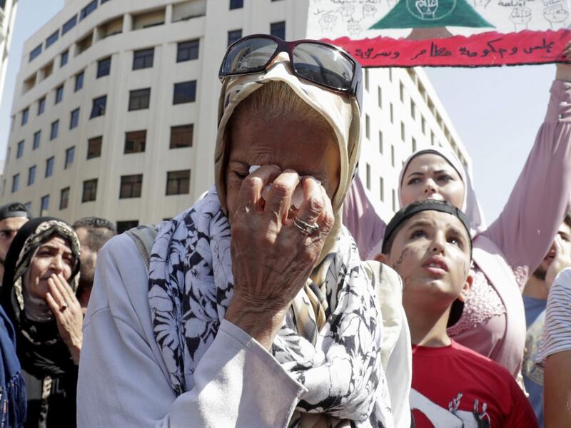 A Lebanese protester wipes her tears during a demonstration in central Beirut's Martyr Square on October 6, 2019. Lebanese protested in the capital over increasingly difficult living conditions, amid fears of a dollar shortage and possible price hikes. ANWAR AMRO / AFP