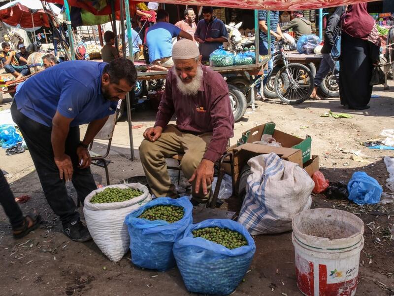 An elderly Palestinian man sell olives at a market during harvest season in Khan Yunis in the southern Gaza Strip on October 6, 2019. SAID KHATIB / AFP