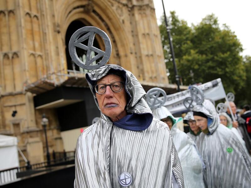 Demonstrators calling themselved 'Aged Agitators' wear the climate change activist group Extinction Rebellion's logo on their heads as they demonstrate outside the Houses of Parliament in central London, on October 7, 2019. Extinction Rebellion has scheduled non-violent protests chiefly in Europe, North America and Australia over the next fortnight. ISABEL INFANTES / AFP