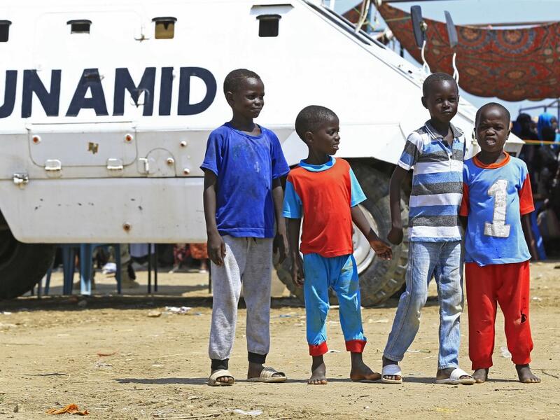 Displaced Sudanese boys pose for a picture in front of a UN-African Union mission to Darfur (UNAMID) vehicle at the Kalma camp for internally displaced people in Darfur's state capital Niyala on October 9, 2019. (AFP/ File)