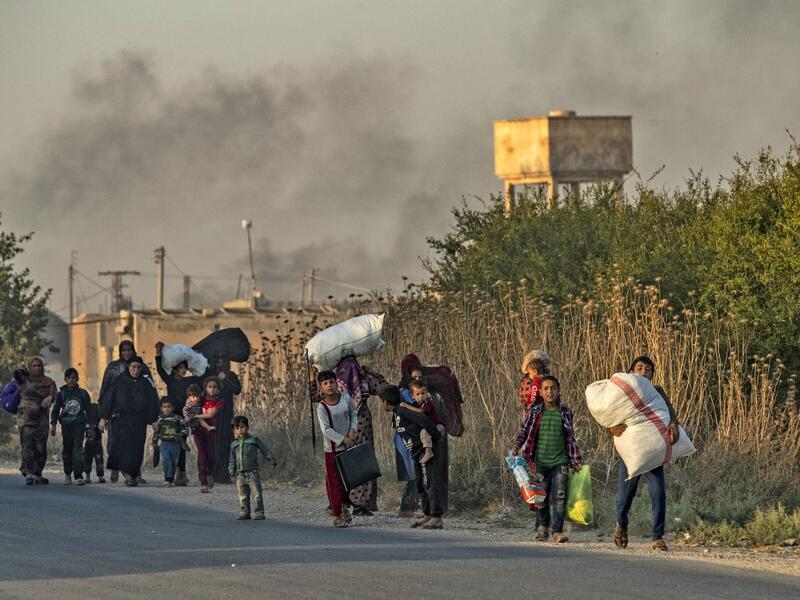 Civilians flee with their belongings amid Turkish bombardment on Syria's northeastern town of Ras al-Ain in the Hasakeh province along the Turkish border on October 9, 2019. Turkey launched a broad assault on Kurdish-controlled areas in northeastern Syria today, with intensive bombardment paving the way for an invasion made possible by the withdrawal of US troops. Delil SOULEIMAN / AFP