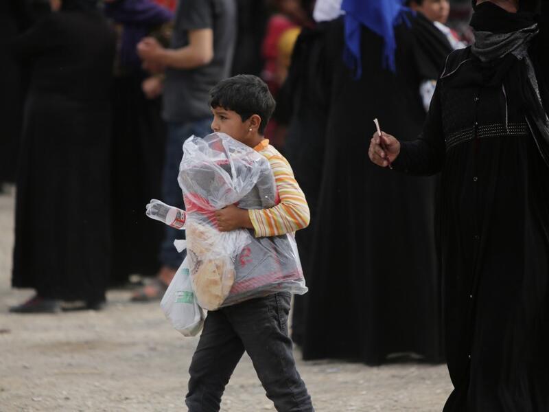 A Syrian girl carries a bag of aid distributed by the Turkish Red Crescent on October 19, 2019, in the Syrian border town of of Tal Abyad seized by Turkey-backed forces last week. Bakr ALKASEM / AFP