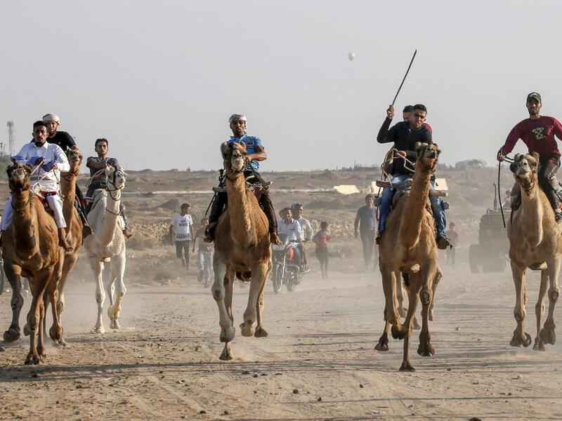 Palestinian jockeys compete during a local camel race held at the destroyed Gaza airport, in Rafah in the southern Gaza Strip on October 20, 2019. SAID KHATIB / AFP