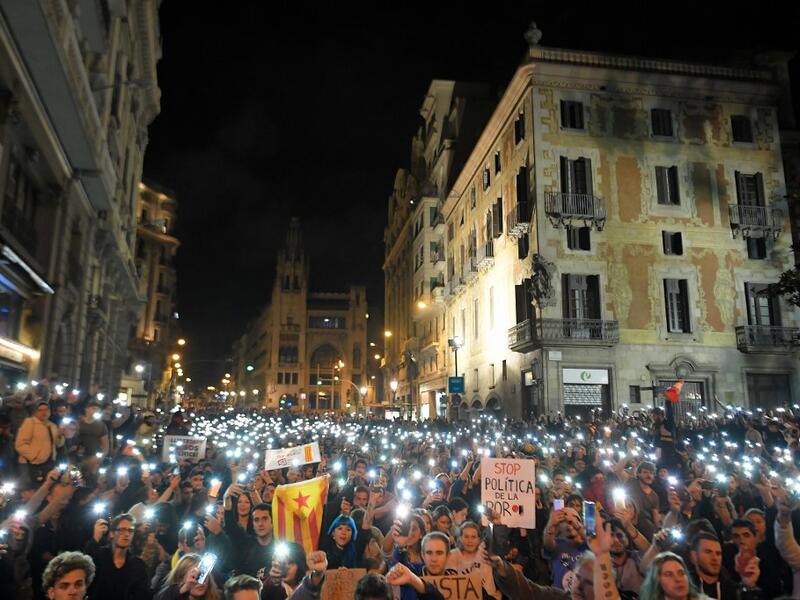 Protesters turn their smartphones' torches on during a protest in front of the Spanish national police headquarters in Barcelona on October 20, 2019. LLUIS GENE / AFP