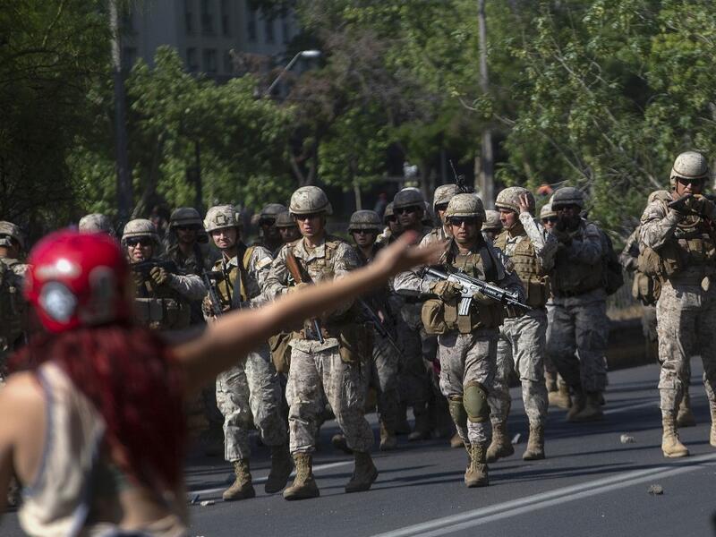 Fresh clashes broke out in Chile's capital Santiago on Sunday after two people died when a supermarket was torched overnight as violent protests sparked by anger over economic conditions and social inequality raged into a third day. (CLAUDIO REYES / AFP)