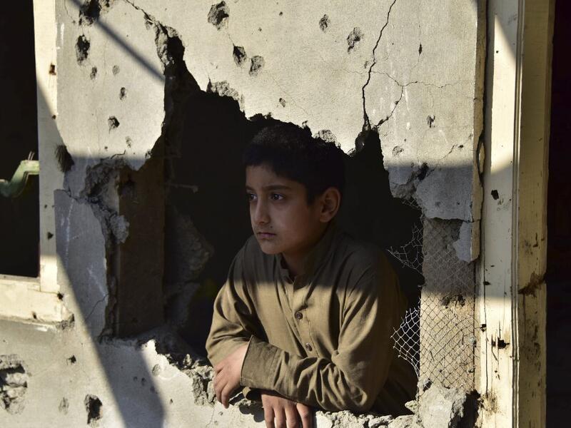 A Kashmiri boy looks out from his damaged family house after cross border shelling in Jura, a village of Neelum valley in Pakistan-administered Kashmir  (AFP)