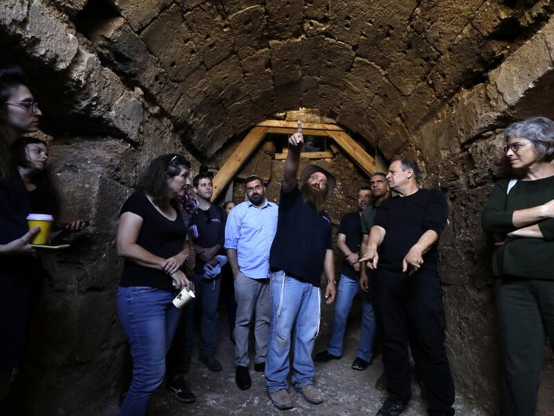 Binyamin Storchan (C), an archaeologist with the Israel Antiquities Authority, shows on October 23 2019 an ancient church crypt in the Israeli city of Bet Shemesh. A magnificent 1500-year-old church, decorated with spectacular mosaic floors and Greek inscriptions, was discovered during a three-year excavation near a residential area. MENAHEM KAHANA / afp