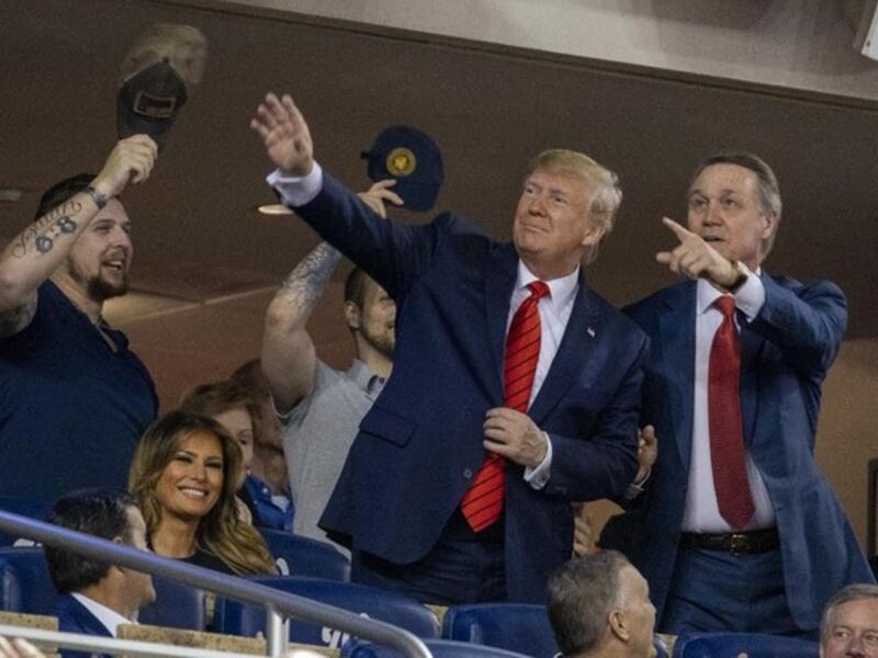President Donald Trump (C) accompanied by Senator David Perdue (R-GA) (R) and a member of the military stand as members of the military are recognized during Game 5 of the World Series between the Washington Nationals and Houston Astros at Nationals Park in Washington, DC on October 27, 2019. (Tasos Katopodis/AFP)