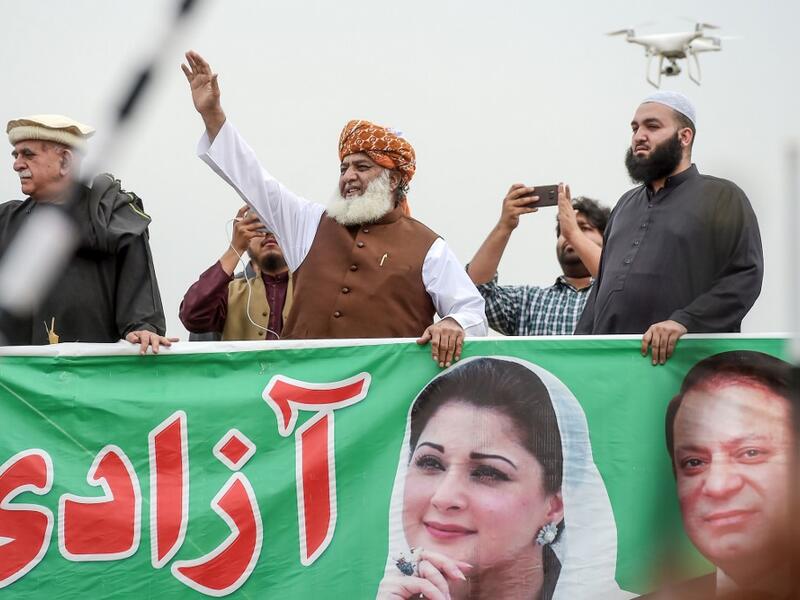 Islamic political party Jamiat Ulema-e-Islam (JUI-F) leader Maulana Fazlur Rehman (C) waves during an anti-government an "Azadi (Freedom) March" in Islamabad. Thousands of Islamists rallied in Islamabad on November 1 as several huge marches from across Pakistan converged on the capital to demand that Prime Minister Imran Khan's government step down. AAMIR QURESHI / AFP