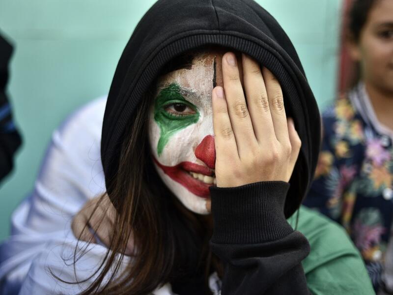 An Algerian demonstrator wearing face paint in the colours of the national flag takes part in an anti-government demonstration in the capital Algiers   RYAD KRAMDI / AFP