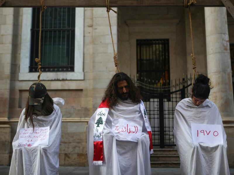 Lebanese protesters stage a mock hanging in a symbolic performance against sectarianism (C), Lebanon's 1975-90 civil war (R) and corruption during ongoing anti-government demonstrations in Downtown Beirut on November 3, 2019. (Patrick BAZ / AFP)