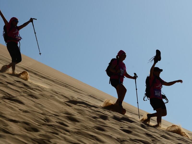 Women run down a sand dune as they take part in the desert trek "Rose Trip Maroc", on November 4, 2019 in the erg Chebbi near Merzouga. The Rose Trip Maroc is a female-oriented trek where teams of three must travel through the southern Moroccan Sahara desert with a compass, a map and a topographical reporter. JEAN-PHILIPPE KSIAZEK / AFP