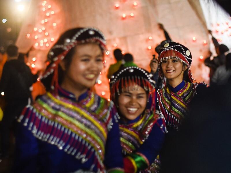 This picture taken on November 4, 2019 shows Wa ethnic women smiling during the Tazaungdaing Lighting Festival at Taunggyi in Myanmar's northeastern Shan State. Brightly coloured balloons with hundreds of homemade fireworks woven into their frames are sent soaring into the night sky, showering down cascades of sparks onto adoring crowds in the annual Taunggyi fire balloon festival. Ye Aung THU / AFP