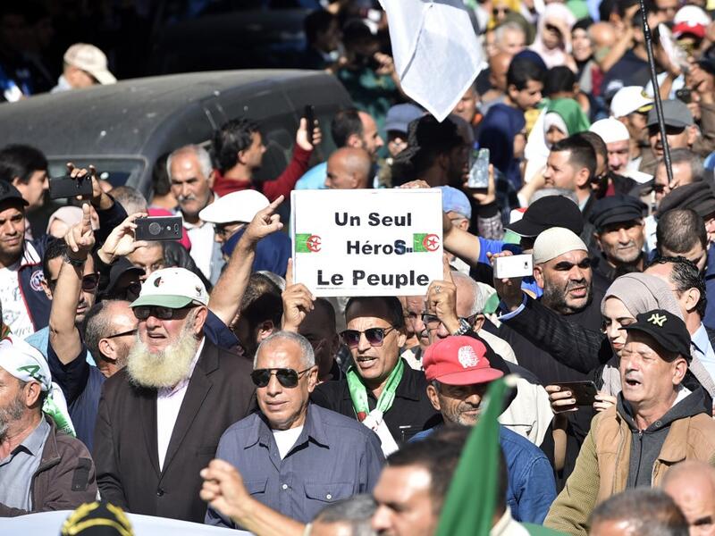Algerians march through the streets of central Algiers as anti-government demonstrations continue on November 5, 2019. French slogan on placard reads: "One hero only, the People." (AFP/ File Photo)