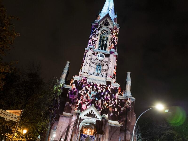 Photos showing mass demonstrations in the former East Germany in 1989 are projected on to the Gethsemane Church as part of the festival week to celebrate the 30th anniversary of the November 9,1989 fall of the Berlin Wall, in Berlin on November 5, 2019. John MACDOUGALL / AFP