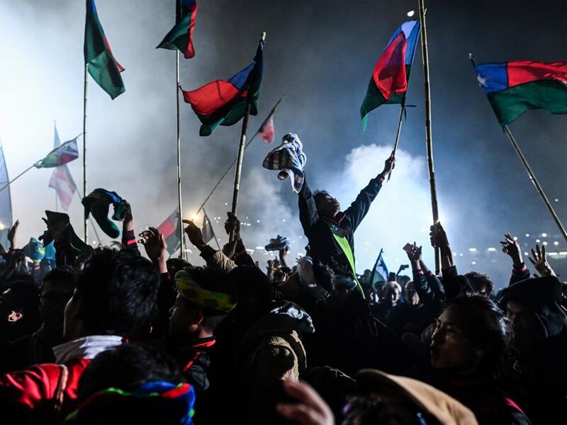 This picture taken on November 5, 2019 shows participants celebrating as fireworks explode after they released a hot-air balloon attached with fireworks during the Tazaungdaing Lighting Festival at Taunggyi in Myanmar's northeastern Shan State. Brightly coloured balloons with hundreds of homemade fireworks woven into their frames are sent soaring into the night sky, showering down cascades of sparks onto adoring crowds in the annual Taunggyi fire balloon festival. Ye Aung THU / AFP