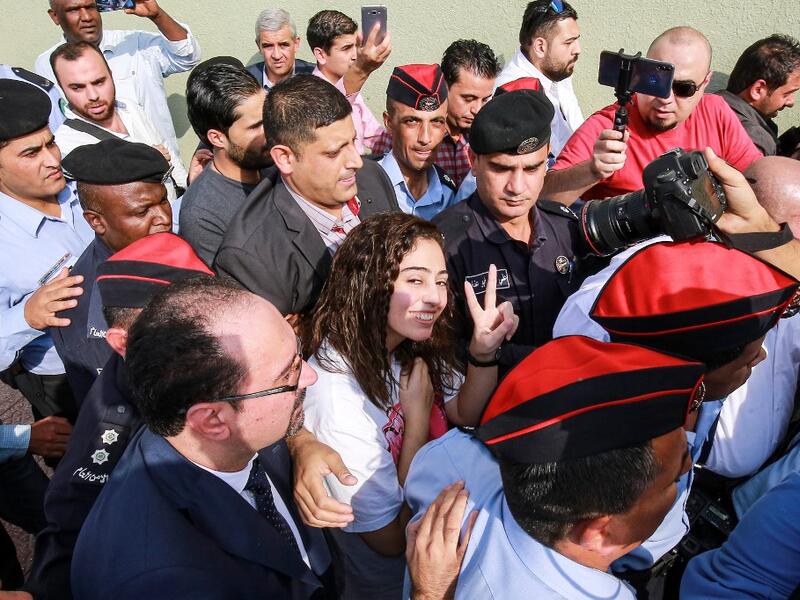 Hiba al-Labadi, a Jordanian national who was held by Israel for several months, flashes the victory gesture upon her release at the King Hussein Bridge (also known as Allenby Bridge) crossing between Israel and Jordan on November 6, 2019. (AFP/ File Photo)