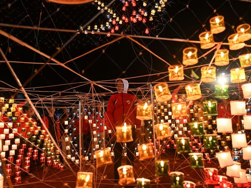 This picture taken on November 6, 2019 shows a reveller looking at lanterns attached to a hot-air balloon with fireworks during the Tazaungdaing Lighting Festival at Taunggyi in Myanmar's northeastern Shan State. Brightly coloured balloons with hundreds of homemade fireworks woven into their frames are sent soaring into the night sky, showering down cascades of sparks onto adoring crowds in the annual Taunggyi fire balloon festival. Ye Aung THU / AFP