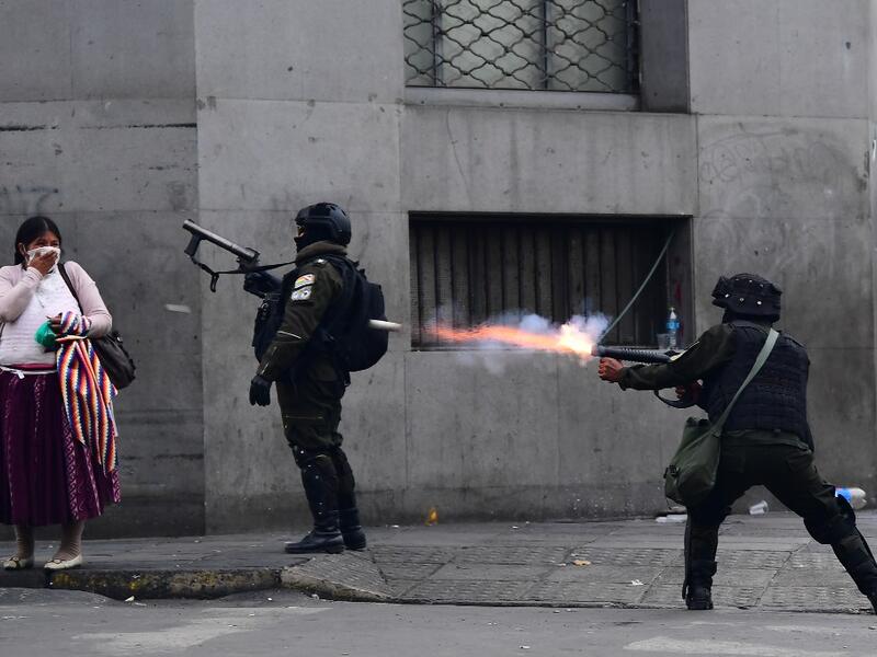 Riot police fire tear gas to disperse supporters of Bolivian ex-President Evo Morales and locals discontented with the political situation during a protest in La Paz on November 13, 2019. Bolivia's exiled ex-president Evo Morales said Wednesday he was ready to return to "pacify" his country amid weeks of unrest that led to his resignation.  RONALDO SCHEMIDT / AFP