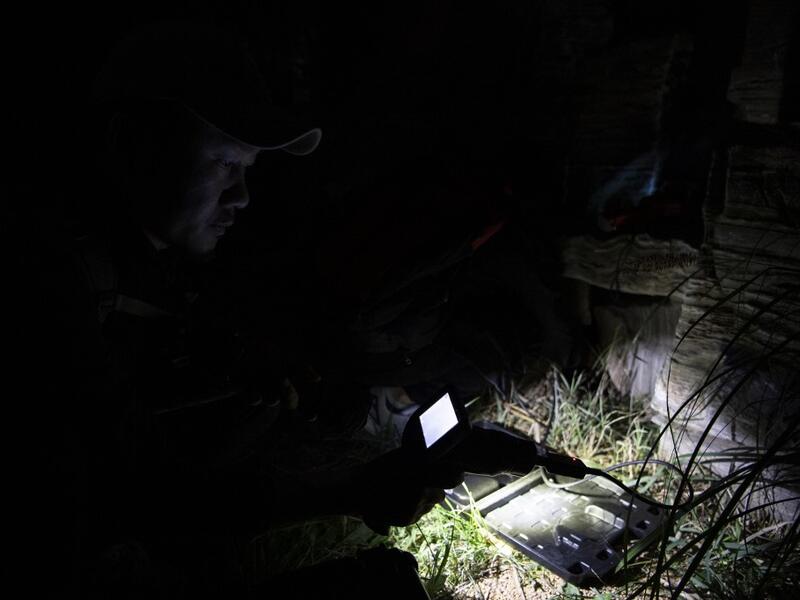 This photo taken on October 23, 2019 shows pet detective Sun Jinrong using a night vision camera as he searches for a missing cat in a residential compound in Beijing. Private sleuth Sun Jinrong brings heat detectors, tiny surveillance cameras, and a blowdart loaded with a tranquiliser to his search for one desperate client's missing loved one: A cat named Duoduo.  NOEL CELIS / AFP